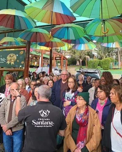 Grupo de excursão recebido na Chácara Santana sob o teto de guarda-sóis coloridos