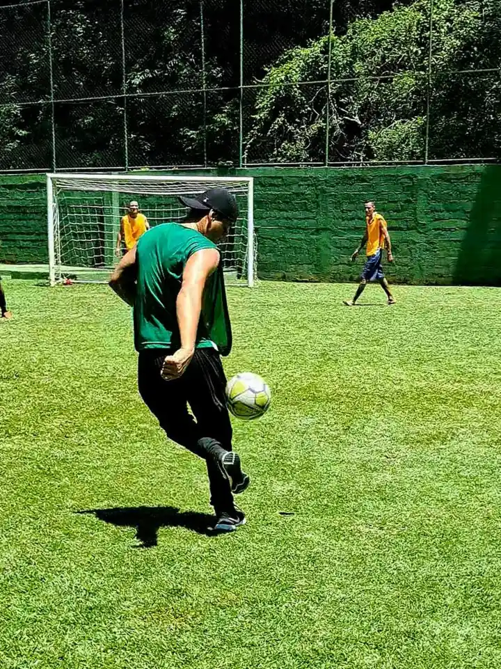Campo de futebol gramado com partida em andamento