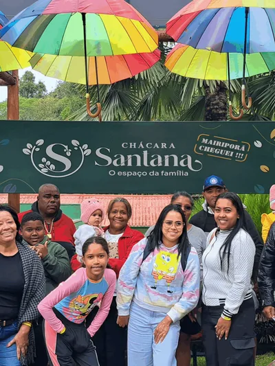 Grupo posando sob o banner da Chácara Santana