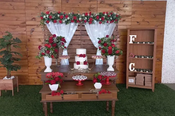 Mesa de bolo decorada com rosas vermelhas e cortina branca