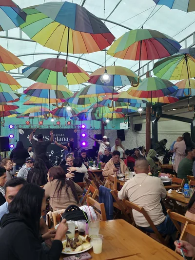 Música ao vivo no palco, com mesas ocupadas
