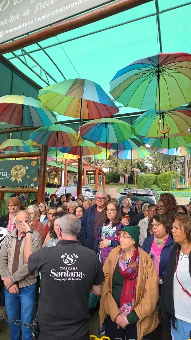 Grupo de excursão recebido na Chácara Santana sob o teto de guarda-sóis coloridos